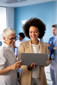 Two ladies reviewing a project on a laptop